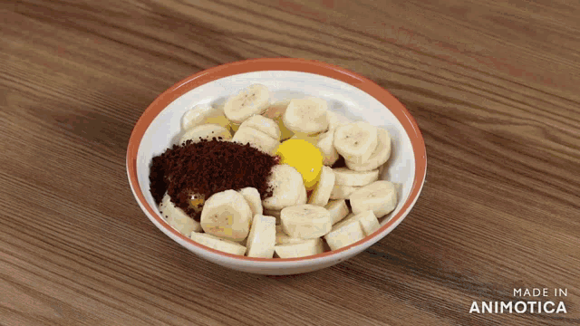 a bowl of sliced bananas with an egg and cocoa powder in it