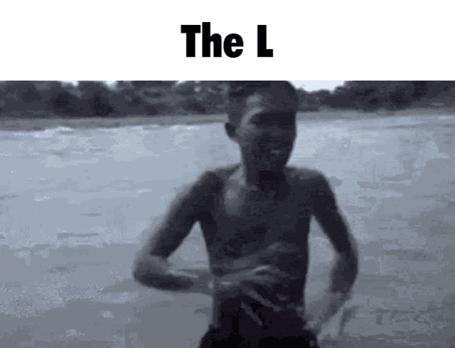 a black and white photo of a shirtless boy standing in the water with the l written above him
