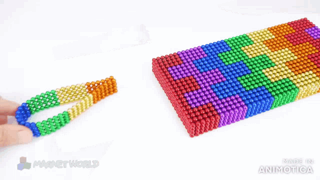 a person is playing with a bunch of colorful beads that are made in animatica