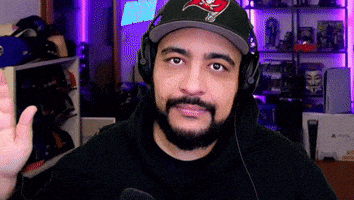 a man with a beard wearing headphones and a hat with a buccaneers logo on it .