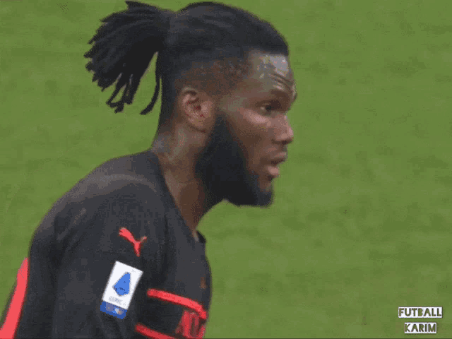 a soccer player wearing a black and red jersey with the word ac milan on it