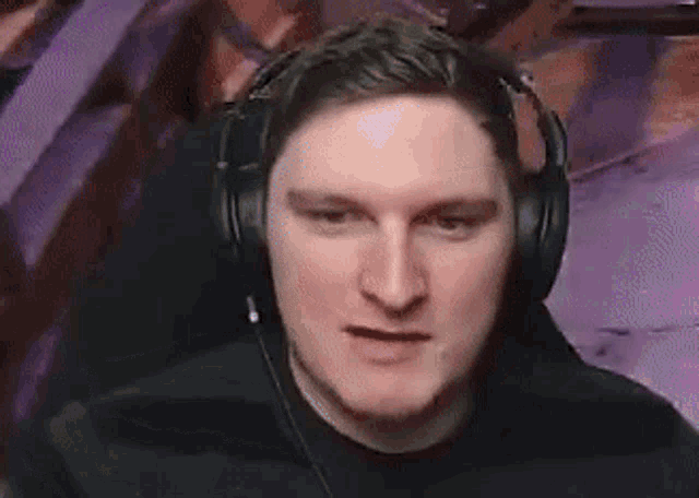 a man wearing headphones is making a funny face and looking at the camera .