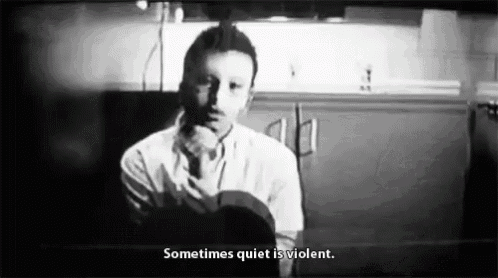a black and white photo of a man in a kitchen with a quote that says `` sometimes quiet is violent '' .