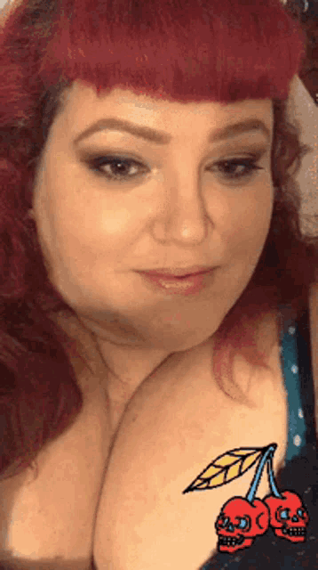 a woman with red hair has two skulls on her chest