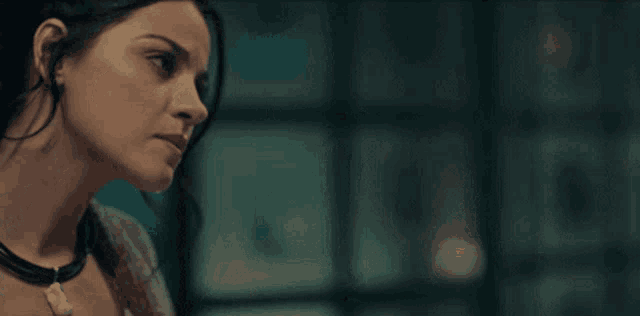 a close up of a woman 's face in a dark room looking down