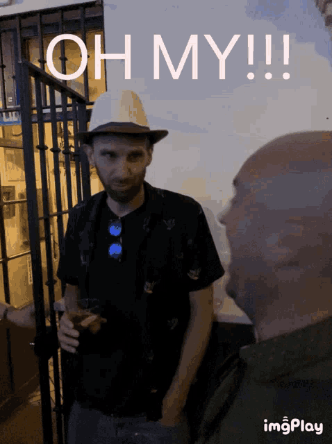 a man wearing a hat is standing next to another man with the words oh my !!! behind him