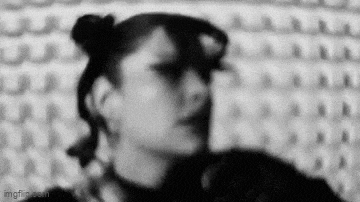 a black and white photo of a woman with two buns in her hair and a ponytail .