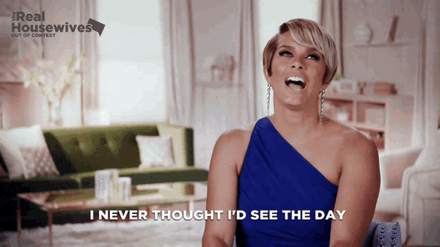 a woman in a blue one shoulder dress says i never thought i 'd see the day