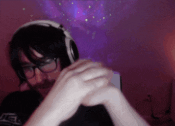 a man wearing glasses and headphones is sitting in front of a purple background