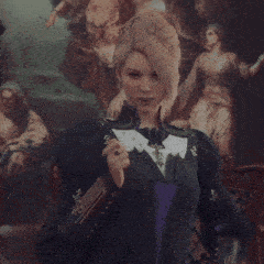 a woman stands in front of a painting with the letter x on her jacket