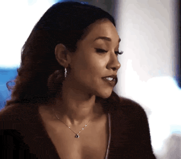 a close up of a woman wearing a necklace and hoop earrings .