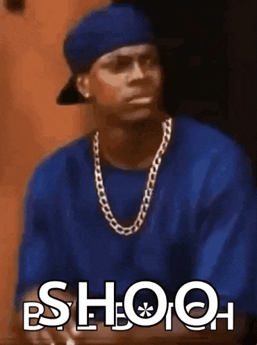 a man in a blue shirt and hat is sitting at a table with the word shooh written on the screen .