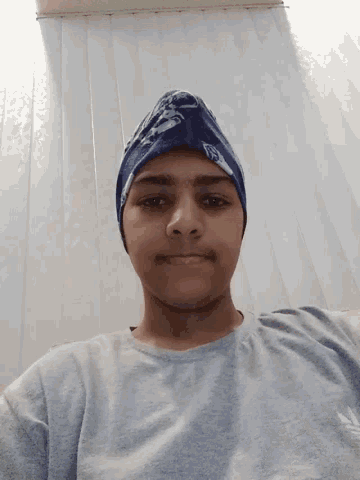 a man wearing a blue bandana with the letter s on it