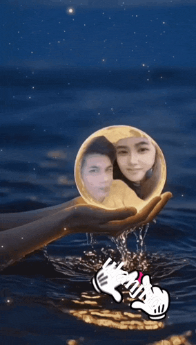 a hand holding a full moon with a picture of a man and a woman in it