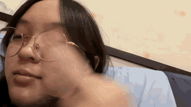 a woman wearing glasses is laying in bed