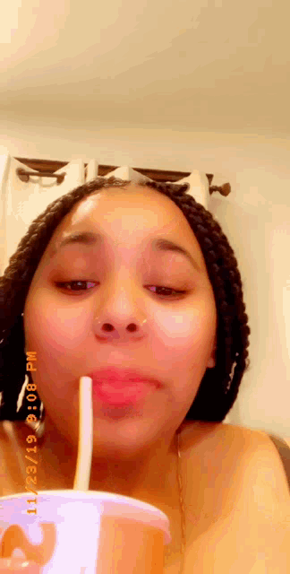 a woman drinking through a straw from a cup that says mcdonald 's