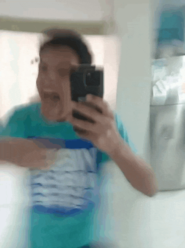 a blurry picture of a person taking a selfie with a cell phone