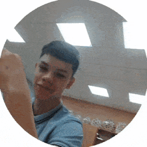 a young man in a blue shirt is taking a selfie in a circle .