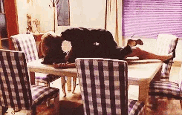 a woman is laying on a table with her legs crossed and a man is kissing her .