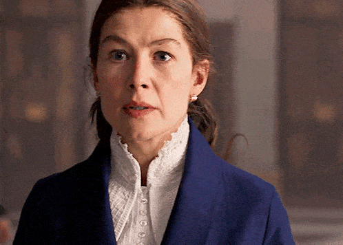 a woman wearing a blue jacket and a white blouse