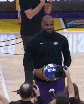 a man holding a wilson basketball in his hands