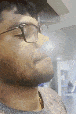 a man with glasses and a beard looks to his left