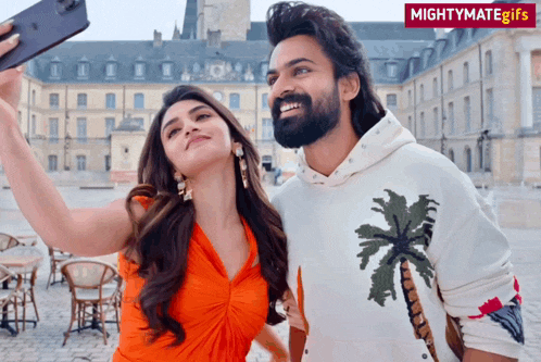 a man and a woman are taking a selfie with a mightymate gif