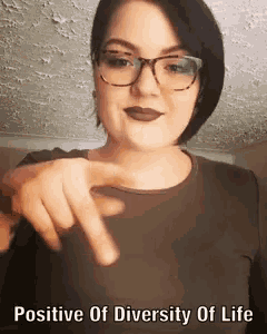 a woman wearing glasses is pointing at the camera with the words positive of diversity of life below her .