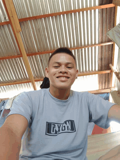 a man wearing a shirt that says gygn is smiling