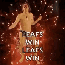 a shirtless man in a bathing suit is dancing in front of fireworks and says `` leafs win leafs win '' .