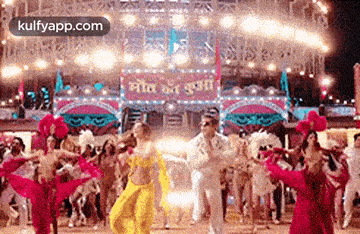 a group of people are dancing on a stage in front of a carnival .