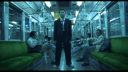 a man in a suit and tie is standing in the middle of a train