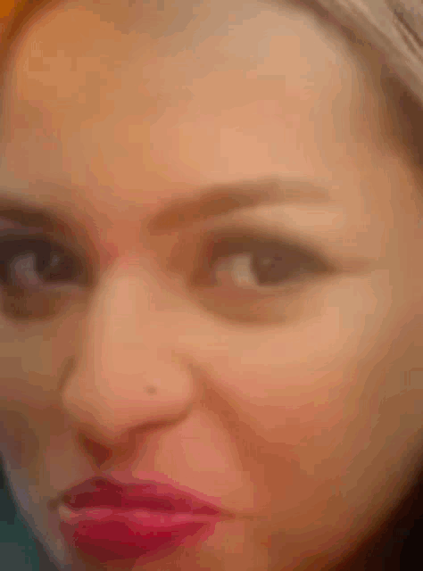 a close up of a woman 's face with red lipstick on her lips