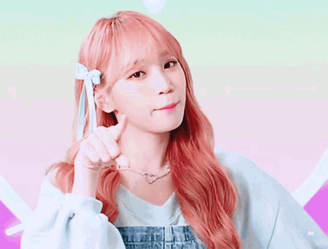 a girl with pink hair and a bow in her hair is pointing at the camera