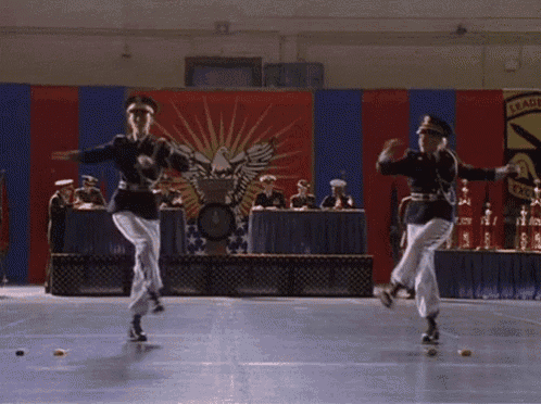 two men in military uniforms are dancing in front of a banner that says " leaders "