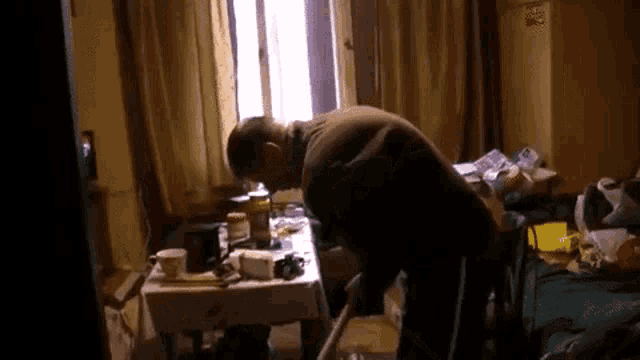 a man is cleaning a messy room with a vacuum