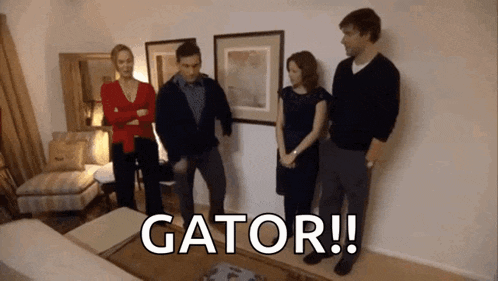 a group of people standing in a living room with the words gator written on the floor