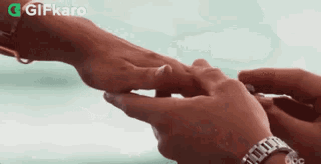 a man is putting a ring on the finger of a woman .