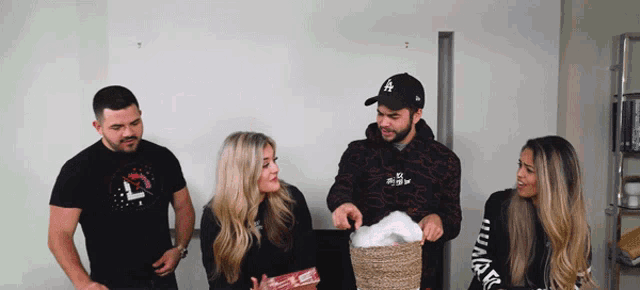 a man wearing a la hat holds a basket of cotton