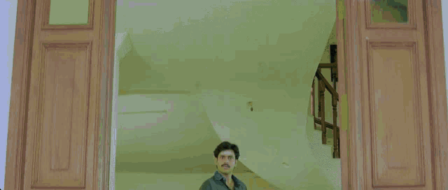 a man in a plaid shirt is standing in a doorway with his arms outstretched
