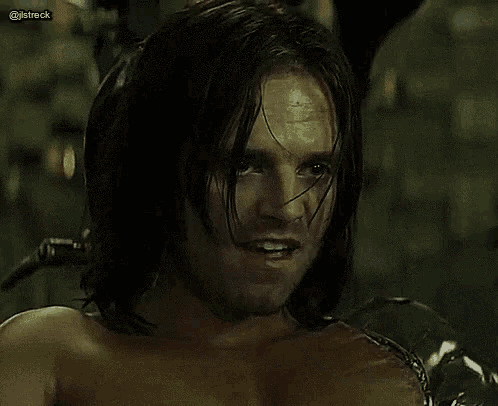 a man with long hair is holding a microphone to his mouth