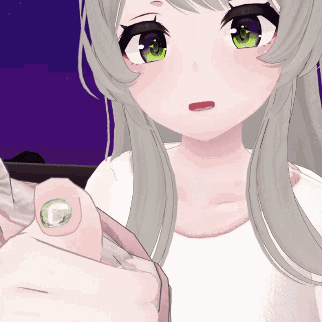 a close up of a girl 's hand with a green stone on it