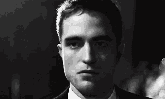 a close up of a man in a suit and tie looking at the camera .