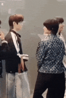 a group of people are standing next to each other in front of a glass wall .