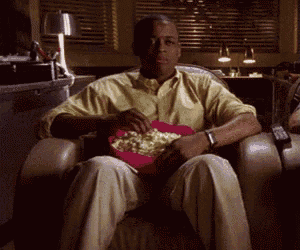 a man sitting in a chair with a bowl of popcorn