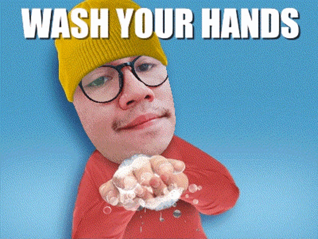 a man wearing glasses and a yellow hat is washing his hands with soap