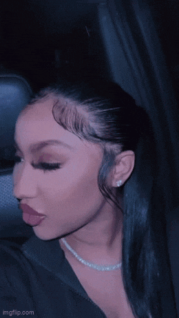 a close up of a woman 's face in a car . she is wearing a necklace and earrings .