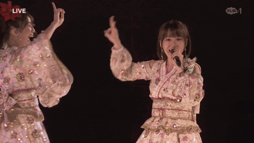a woman singing into a microphone with the word live on the bottom right