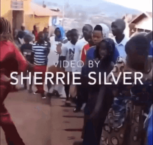 a video by sherrie silver shows a crowd of people dancing on a street