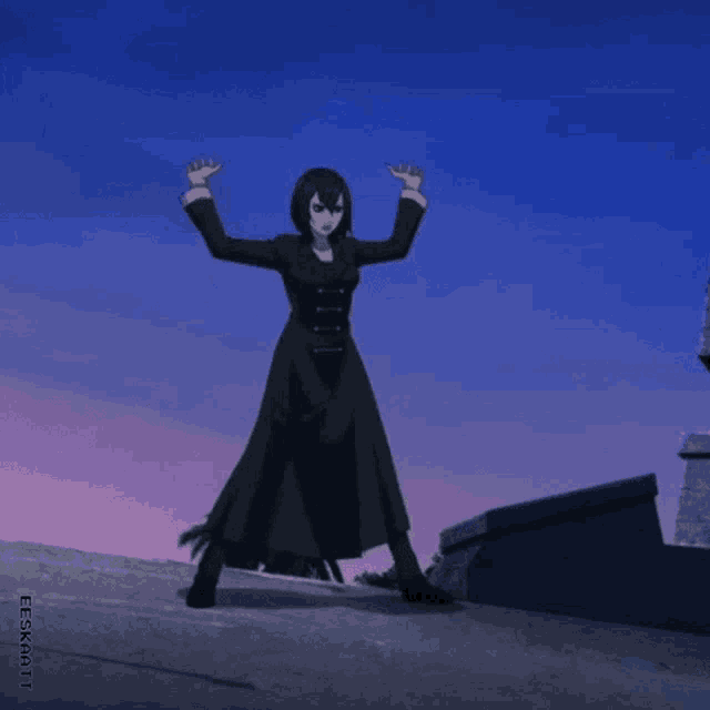 a woman in a black dress is standing on a ledge with her arms up